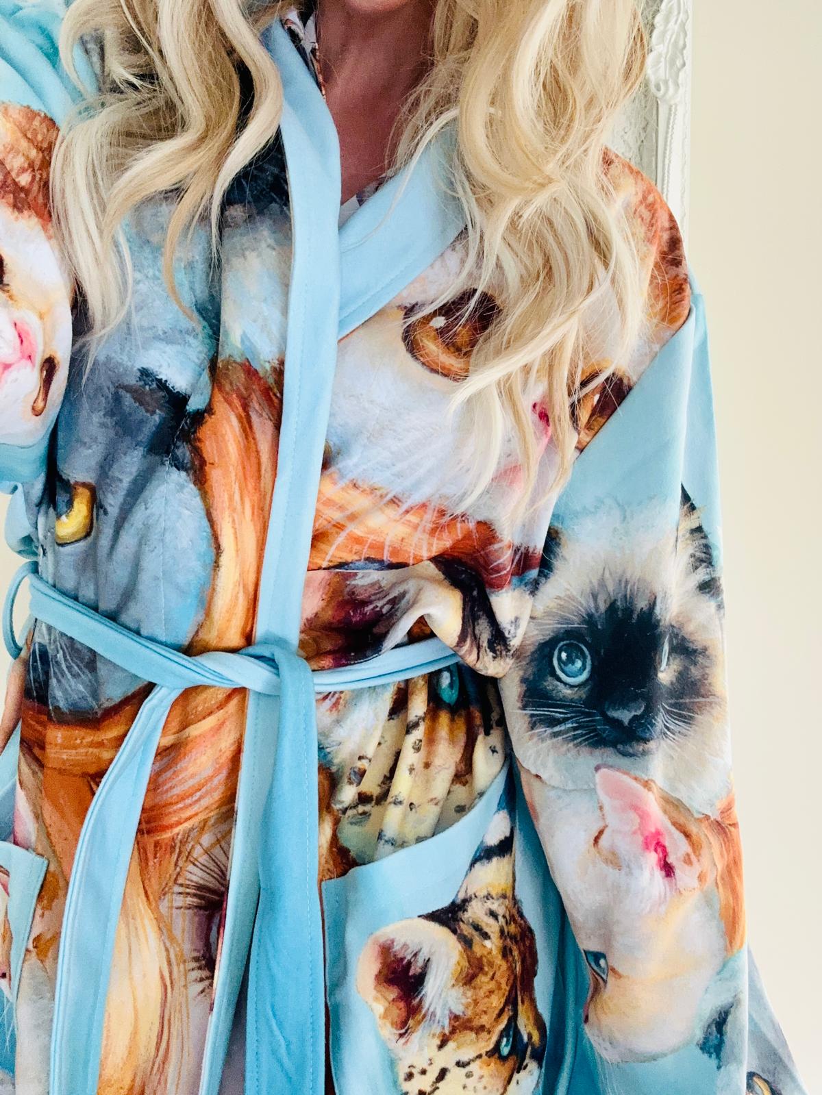 Woman wearing a bath robe with cat print  design